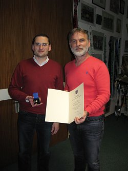 Marko Wartmann wird von Landrat Harald Zanker mit dem Ehrenbrief des Freistaates Th&uuml;ringen geehrt.  (Foto: Foto: Landratsamt)