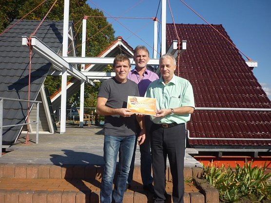 Frank Bellstedt (l.) Landrat Harald Zanker und Wolfgang Hausd&ouml;rfer, Gesch&auml;ftsf&uuml;hrer der Unternehmensgruppe Creaton AG bei der symbolischen Scheck&uuml;bergabe. (Foto: Foto: Landratsamt)