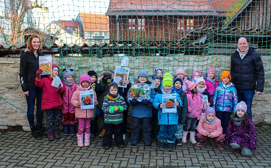 Diana Ludwig (links) und Michael Zilling (rechts) vom Baumkronenpfad gratulier- ten den Kindern der Kita Salzaknirpse zum 1. Platz im K&uuml;rbiswettbewerb. (Foto: &copy; KTL Kur und Tourismus Bad Langensalza GmbH, Stefanie K&ouml;nig)