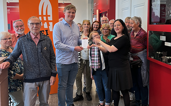 G&auml;stef&uuml;hrer Philipp Bert (4. v.l.) leitete die 500. F&uuml;hrung durch die Th&uuml;ringer Landesausstellung � daf&uuml;r erhielt er von Direktorin Dr. Susanne Kimmig-V&ouml;lkner (3. v.r.) ein Pr&auml;sent als Dankesch&ouml;n. (Foto: M&uuml;hlh&auml;user Museen)