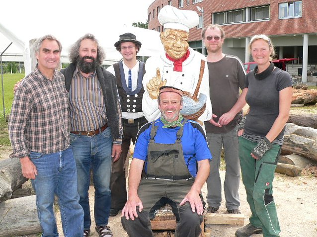Bild: Auch in diesem Jahr findet der Holzbildhauer-Workshop im Ma&szlig;regelvollzug am Tag der offenen T&uuml;r seinen Abschluss. Heinz G&uuml;nther (m.) im Kreise seiner Kollegen.
