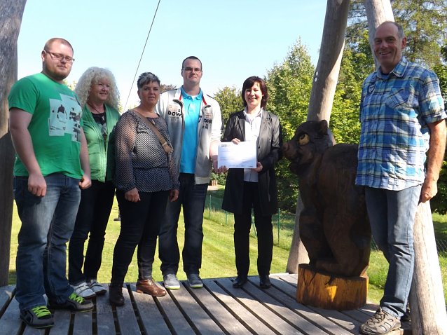 Bild: Gemeinsam mit der Geldspende wurde auch die lebensgro&szlig;e Holzskulptur eines Braunb&auml;ren an das Hospiz &uuml;bergeben.
