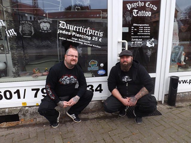 Bild: Ronny Krauser (l.) und Mitarbeiter Marc Rehbein haben das Notinsel-Logo an der Schaufensterscheibe des Gesch&auml;ftes angebracht