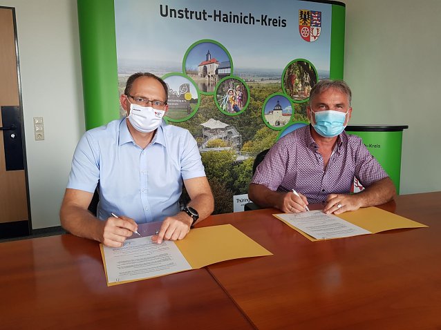 Bild: Michael Watterott und Harald Zanker bei der Unterzeichnung des Vertrages (v.l.n.r.) im Landratsamt Unstrut-Hainich-Kreis.