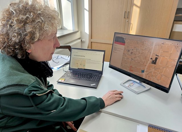 Bild: Frau vor einem Computer mit einer digitalen Karte