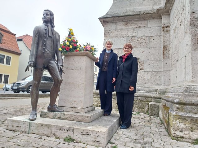 Bild: Zwei Personen vor einem Denkmal f&uuml;r Johann Sebastian Bach