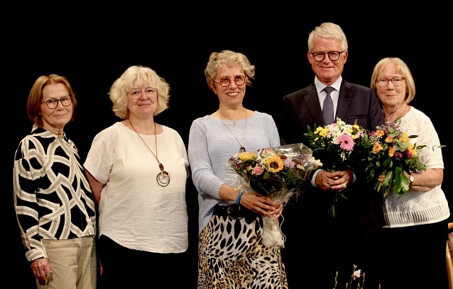 Bild: Vier Frauen und ein Mann vor dunklem Hintergrund