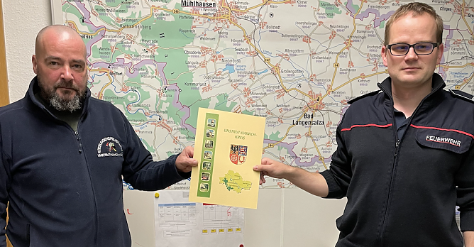 v.l.: Kreisjugendfeuerwehrwart Andreas Kr&uuml;ger und Kreisbrandinspektor Florian Krieg bei der &Uuml;bergabe des Bescheides (Foto: Landratsamt UHK)