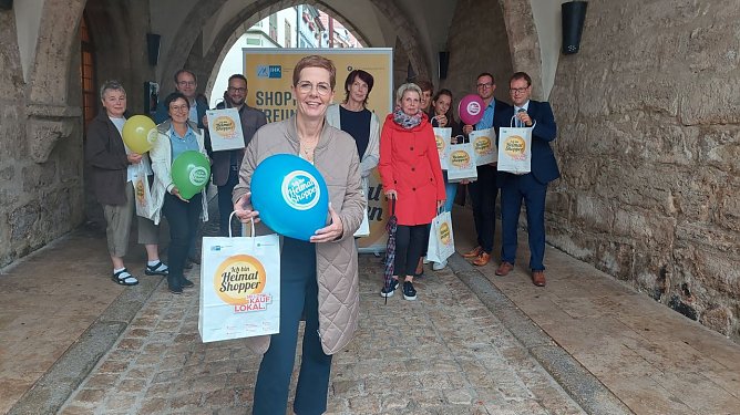 Modegesch&auml;fts-Inhaberin Barabara Endepols (vorn) stellte gemeinsam mit den Einzelh&auml;ndlerinnen Annegret Spallek, Petra Wehrsporn und Silke Ressel, Oberb&uuml;rgermeister Dr. Johannes Bruns, Birte Frerichs vom Stadtmarketing, Jan Riemann vom Verein ZiM, Susanne Sturm und Marcel &Uuml;bensee von der IHK Erfurt sowie Sparkassen-Vorstand Christian Blechschmidt das Angebot zum M&uuml;hlh&auml;user Heimatshoppen 2022 vor. (Foto: Stadtverwaltung M&uuml;hlhausen)