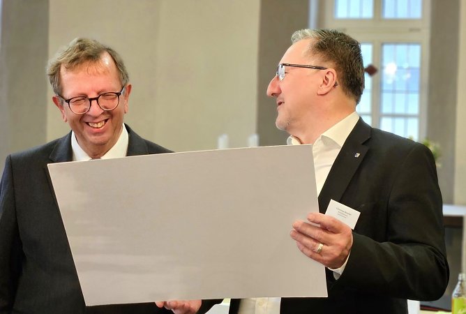 Dr. Werner Henning erh&auml;lt einen Gutschein aus den H&auml;nden von Superintendent Christian Beuchel (Foto: Regina Englert, Evangelischer Kirchenkreis M&uuml;hlhausen)